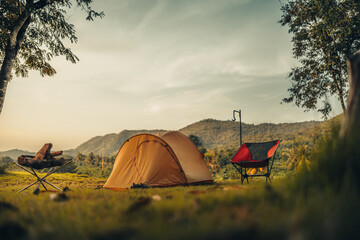 A tent on the grass with a view of the mountains in the background and sunlight. Holiday, Travel, Long weekend, Vacation and camp concept. © Charnchai saeheng