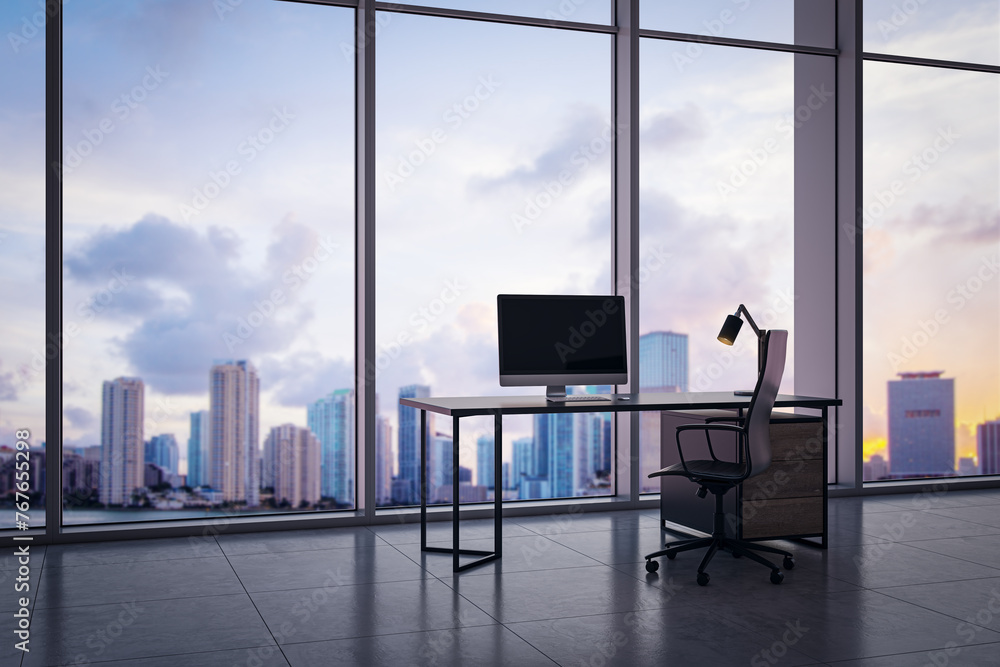 Aufkleber Modern office interior with empty computer screen on desk and panoramic windows with beautiful city view and daylight. Mock up. Workplace concept. 3D Rendering.