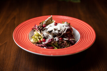 vegan beetroot salad served in red dish in restaurant on dark background