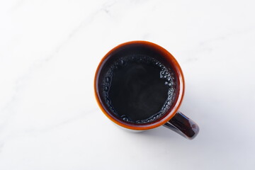 お気に入りのマグカップに淹れたてのコーヒーを入れてひと休みしているイメージ
