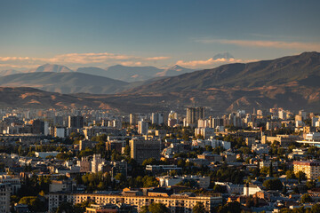 View of Tbilisi from the surrounding hills. In the background you can see the Caucasus Mountains. A warm autumn day in the capital of Georgia. - 767667498