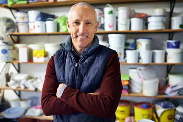 Portrait, man and confidence of happy store owner in business or retail for plastic in startup. Face, arms crossed and mature professional in shop, entrepreneur and smile of manager in Switzerland