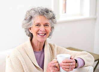 Sofa, coffee and portrait of elderly woman in living room for morning, weekend and retirement. Relax, smile and senior person with happiness for warm beverage, drink and satisfaction at home