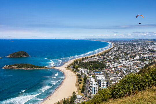 Paraglider soars over Mount Maunganui beach in Tauranga summer