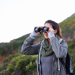 Woman, hiking and outdoor in nature with binoculars for vision for fitness, location and memory on adventure. Girl, person and trekking in bush, mountains and scenic view on vacation in Cape Town