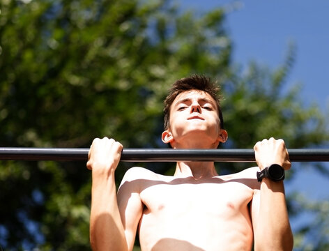 Young person doing pullups outside
