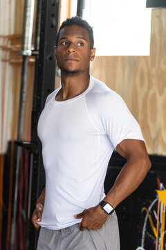 Fit Man in Gym Adjusting White Shirt