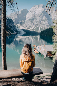 Female tourist in Italy looking at lake while sitting on bench