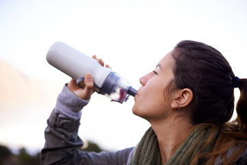 Woman, hiking and outdoor to drink with bottle, water and hydration for health, fitness and...