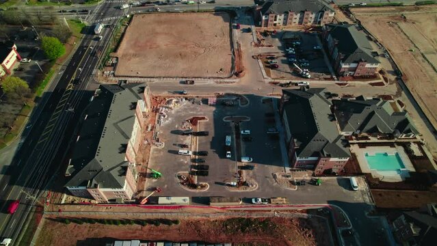 Green Lifting equipment in action, construction site for residential home complex in South Atlanta, Georgia, USA. Telescopic Boom Lift, scissor lift.