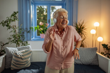 Elderly woman enjoying her music at home - 767685608