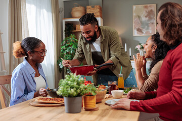 Man pouring her friend some pasta during friends lunch date