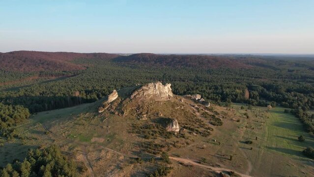 Drone rotating view of a dramatic rock formation surrounded by a dense forest. Biaklo, Little Giewont, Poland, Czestochowa, Olsztyn Jurajski, polish jura, Polish Jurassic Highland