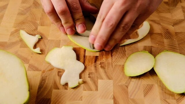 Cutting from a slice of a pear with a mold for cookies of a rabbit figure for a decor of Easter sandwich or fruit dessert. Easter concept. Food Styling. Children's recipes
