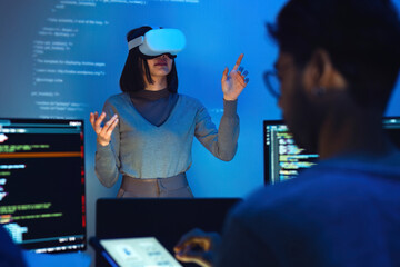 asian and Indian developer devops team testing  virtual reality coding and presentation  with ai prompt  at night in office - 767692828