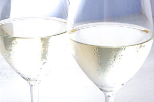 白ワインが注がれたふたつのワイングラスで乾杯のイメージ
