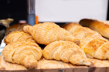 Close-up of freshly baked pastry products displayed in a bakery. Fresh croissant