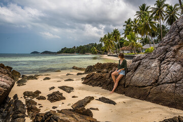 Kobieta na rajskiej plaży na kamieniu