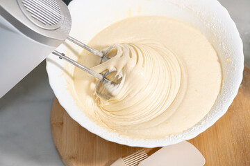 A bowl of dough is mixed with a mixer. Food concept. - obrazy, fototapety, plakaty