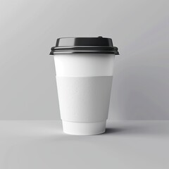 A white coffee cup with a black lid and a white sleeve. The cup is sitting on a gray surface