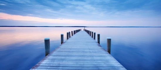 Foto op Canvas Tranquil Wooden Pier Over Serene Lake at Dusk © evening_tao