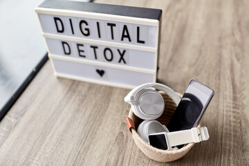 technology concept - digital detox words on light box and different gadgets on blue background - 767716869