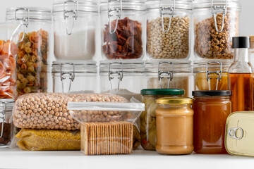 food storage and eating concept - close up of different cereals, groceries and preserves on table - 767718623
