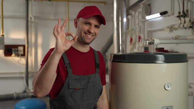 A skilled plumber in uniform is examining a residential water heater in a basement, ensuring proper functionality and safety of the appliance. His expertise is evident as he meticulously checks for