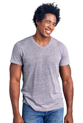Handsome african american man with afro hair wearing casual clothes winking looking at the camera...
