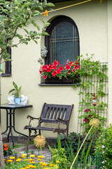 Fototapeta na wymiar Beautiful blooming flowers on window sill outside of cozy house. 