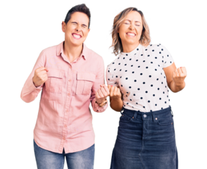 Couple of women wearing casual clothes very happy and excited doing winner gesture with arms raised, smiling and screaming for success. celebration concept.