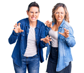 Couple of women wearing casual clothes smiling funny doing claw gesture as cat, aggressive and sexy expression