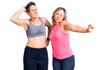 Couple of women wearing sportswear stretching back, tired and relaxed, sleepy and yawning for early morning