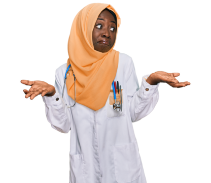 Beautiful african young woman wearing doctor uniform and hijab clueless and confused expression with arms and hands raised. doubt concept.
