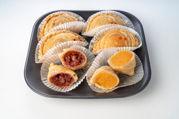 Curry puff on black plate on white background, Curry puff pastry on white background.