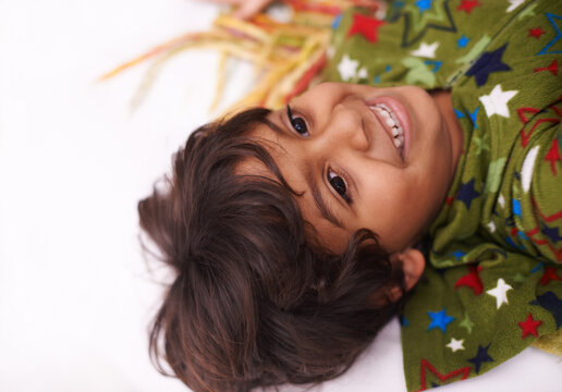 Children, thinking and boy on a floor happy, chilling or imagine, playful or brainstorming at home. Night, smile and curious Indian kid in a living room in India with bedtime fun, memory or fantasy