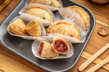 Curry puff on black plate on wooden background, Curry puff pastry on wooden table.