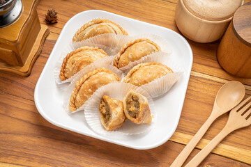 Chicken Curry puff on white plate on wooden background, Curry puff pastry on wooden table.