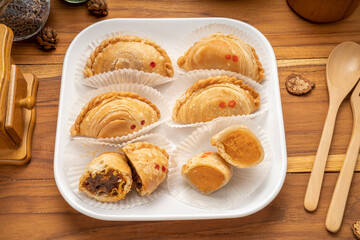 Curry puff on white plate on wooden background, Curry puff pastry on wooden table.