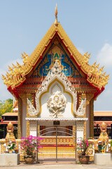 Ornate Thai Temple Facade with Golden Detailing under Clear Blue Sky
