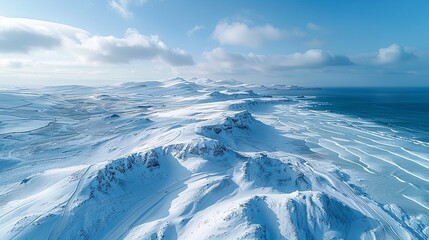 A view of rolling hills covered in white snow, with paths made by visitors, offers a sense of silence and peace.