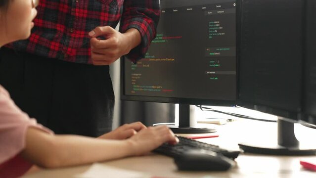 Slow motion back end or software developer manager supervising his team on new application program development on debugging and solving complex code algorithms on monitor. Burgeoning