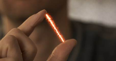 Red stream of energy appears between fingers. Visual effect, close-up. Concept of measuring...