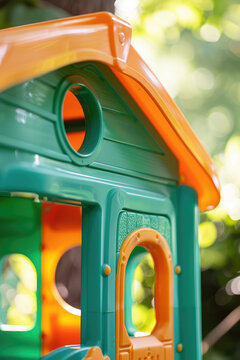 Children's Outdoor Plastic Playhouse in Sunlit Garden, copy space. Vibrant toy house nestled in green summer backyard.