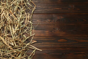 Dried hay on wooden background, flat lay. Space for text