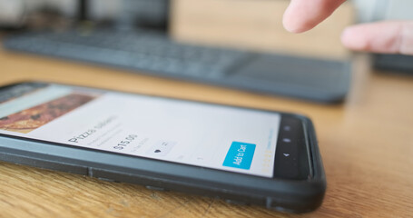 Man's finger presses add to cart button on smartphone screen. Side view, close-up, pizza order. Concept of online shopping, purchase food delivery.
