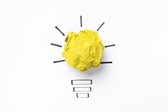 Idea concept. Light bulb made with crumpled paper and drawing on white background, top view