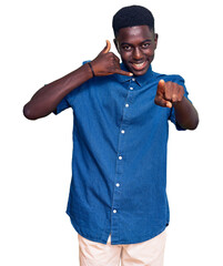 Young african american man wearing casual clothes smiling doing talking on the telephone gesture...