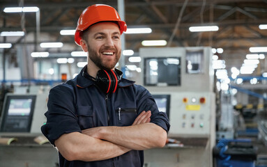 Front view. Factory worker is indoors with hard hat