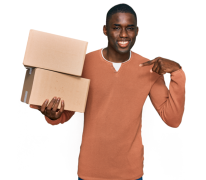 Young african american man holding delivery package pointing finger to one self smiling happy and proud